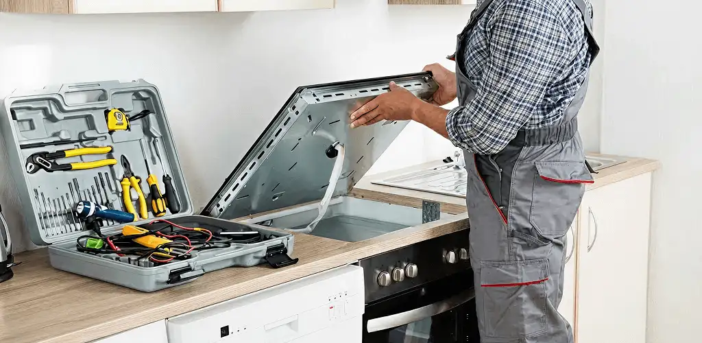 Handyman repairing a cooktop and checking wiring connections in Savannah, GA
