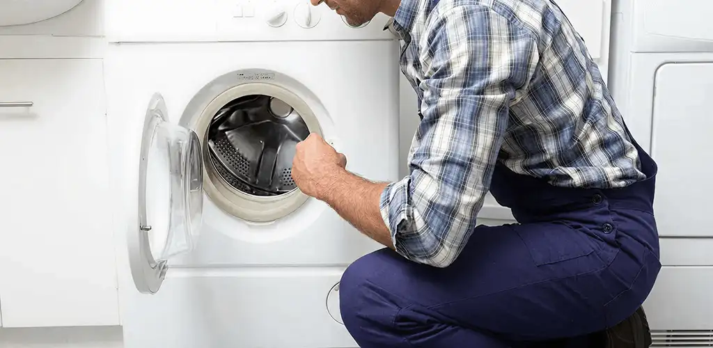 Handyman inspecting a dryer drum and internal parts for repair in Savannah, GA