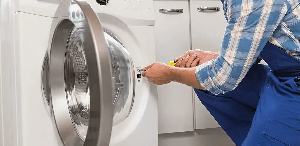 Handyman repairing a clothes dryer and checking electrical connections in Savannah, GA