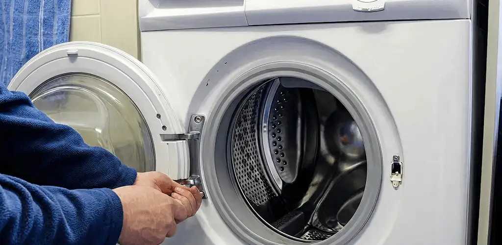 Washing machine repair handyman checking a front-load washer door and latch in Savannah, GA