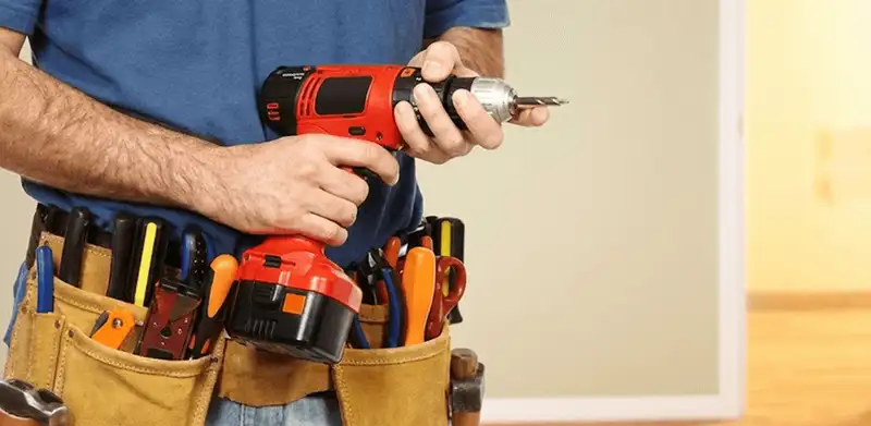 Handyman holding a power drill for home repairs and installations in Savannah, GA