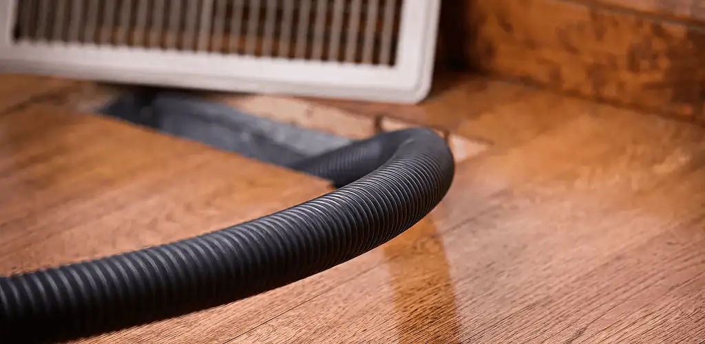 Air duct cleaning hose inserted into a floor vent for ductwork cleaning in Savannah, GA