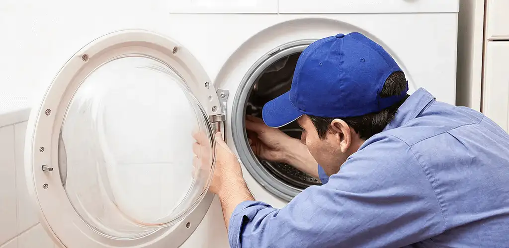 Washing machine repair handyman inspecting a front-load washer drum in Savannah, GA